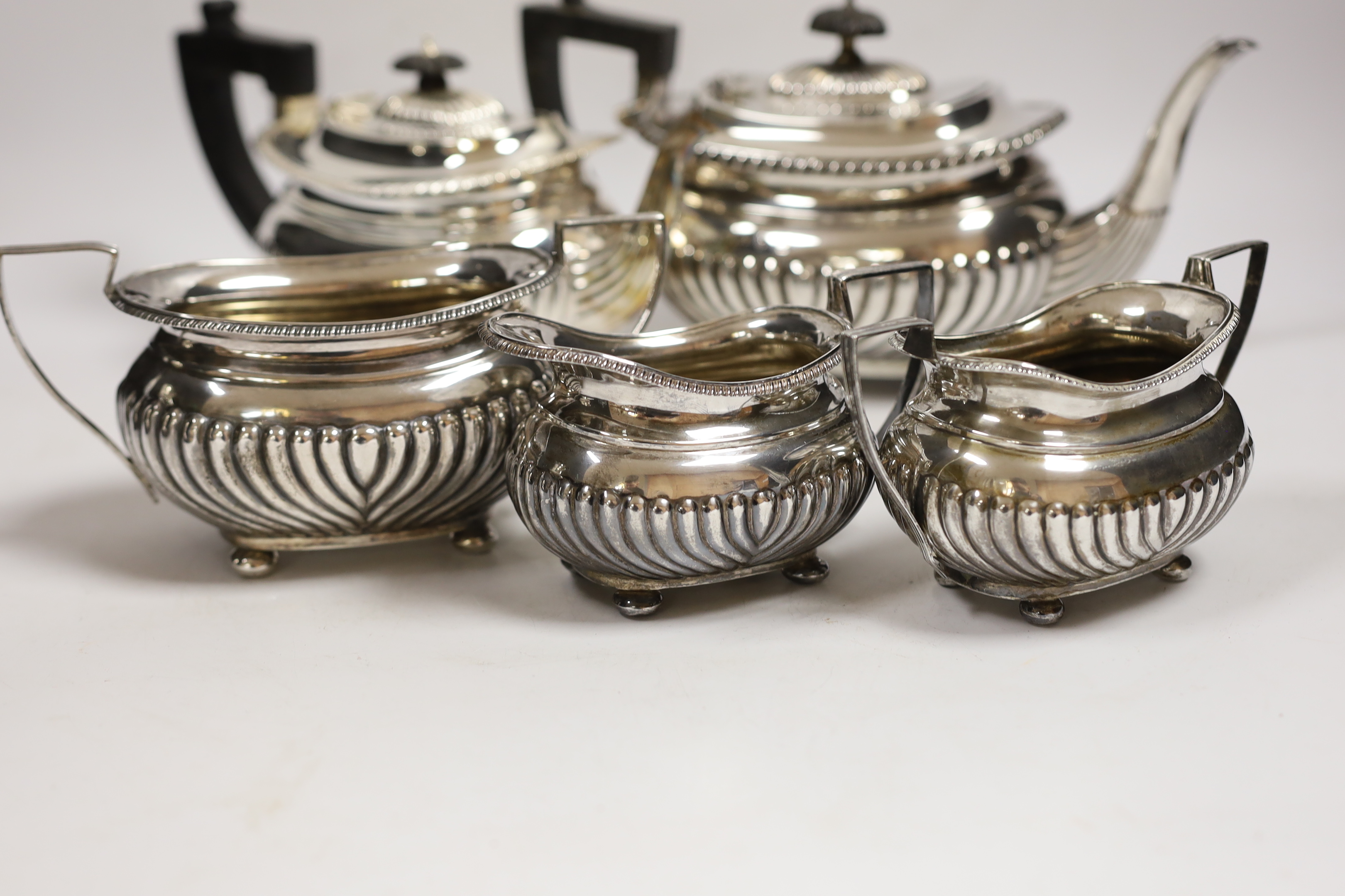A late Victorian demi fluted silver three piece tea set, William M. Hayes, Birmingham, 1897, together with another demi fluted silver teapot and sugar bowl, same maker, Birmingham, 1898, gross weight 52.6oz.